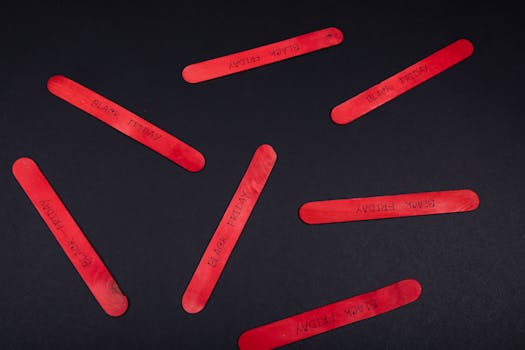 Red popsicle sticks arranged on a black background with Black Friday text.