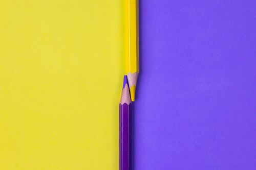 Free Bright yellow and purple colored pencils aligned creatively with a minimalistic design. Stock Photo