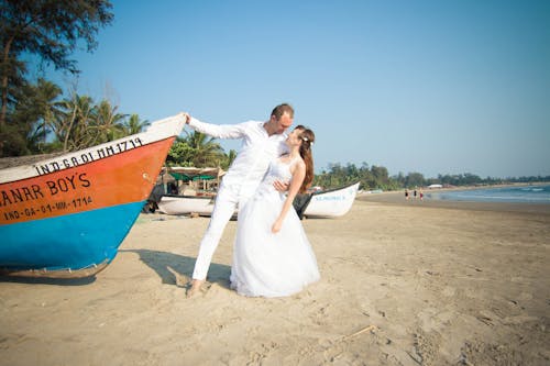 Bride and Groom Standing Near the Wooden Boat
