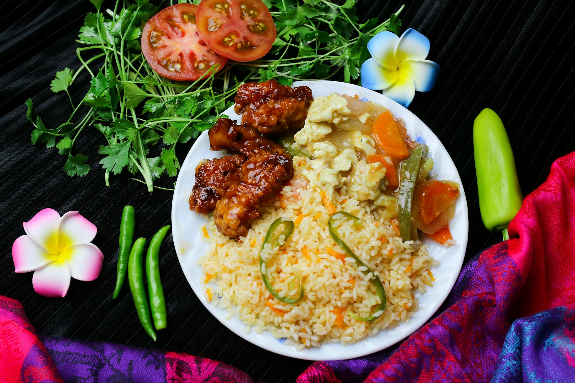 Delicious Asian fusion cuisine featuring fried rice, vegetables, and grilled meat with garnishes.