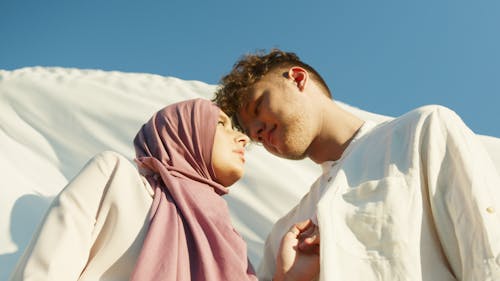 
Woman in Purple Hijab Looking at Man in White Chinese Collar Shirt