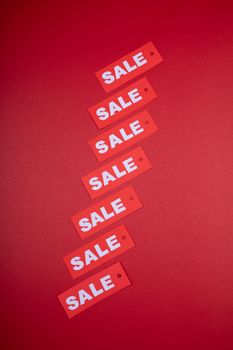 Vertical arrangement of red sale tags on a vivid red background, ideal for retail promotions. - Fotografer Sidoarjo