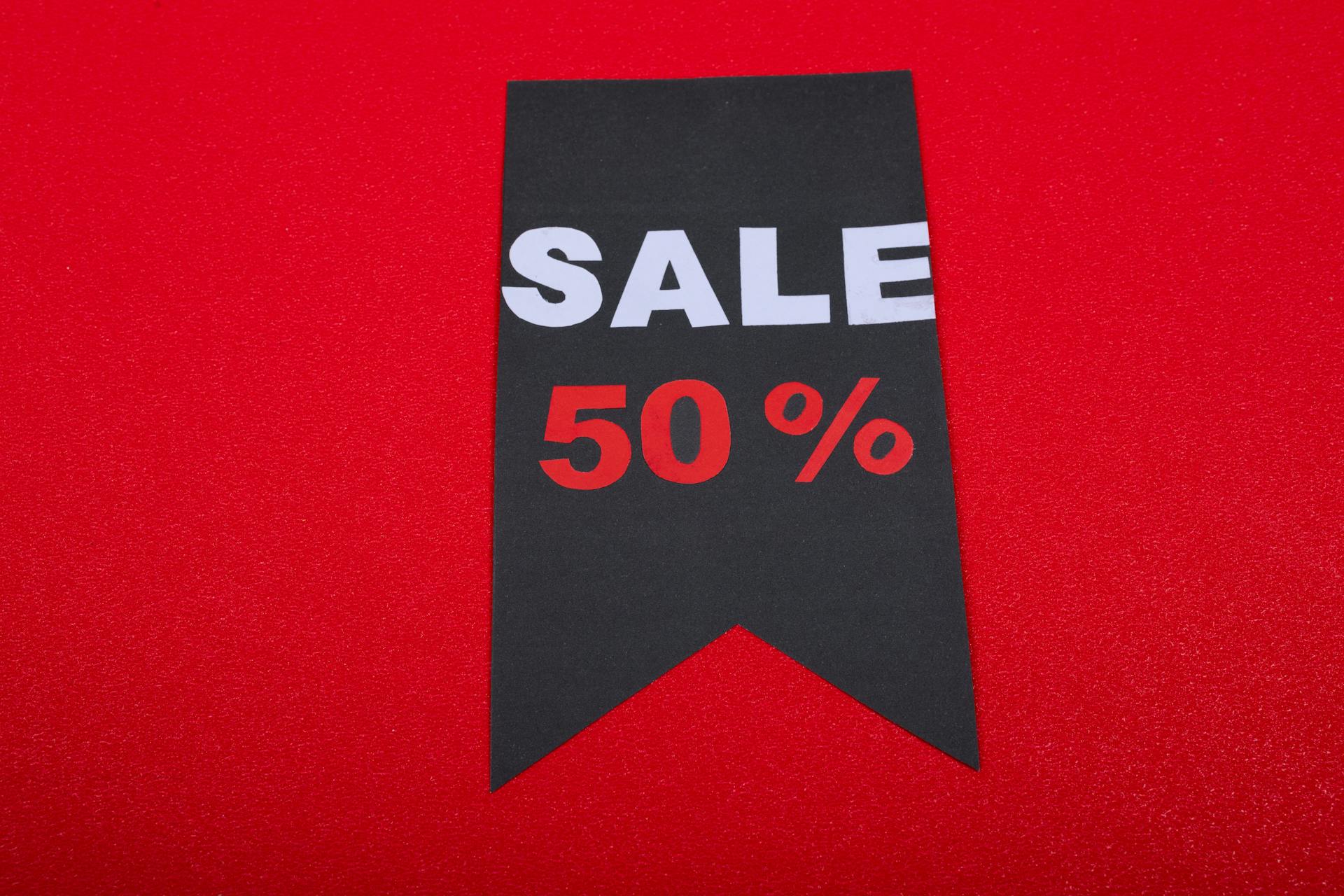 Modern sale tag offering 50% discount on vibrant red background.