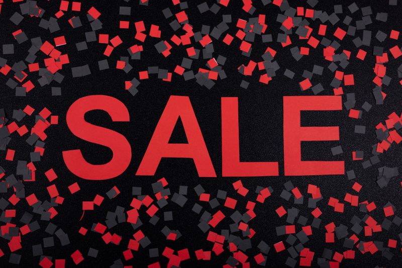 A festive red and black sale banner surrounded by confetti, perfect for promotions.