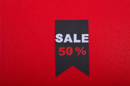 Paper Sale Sign on a Red Wall