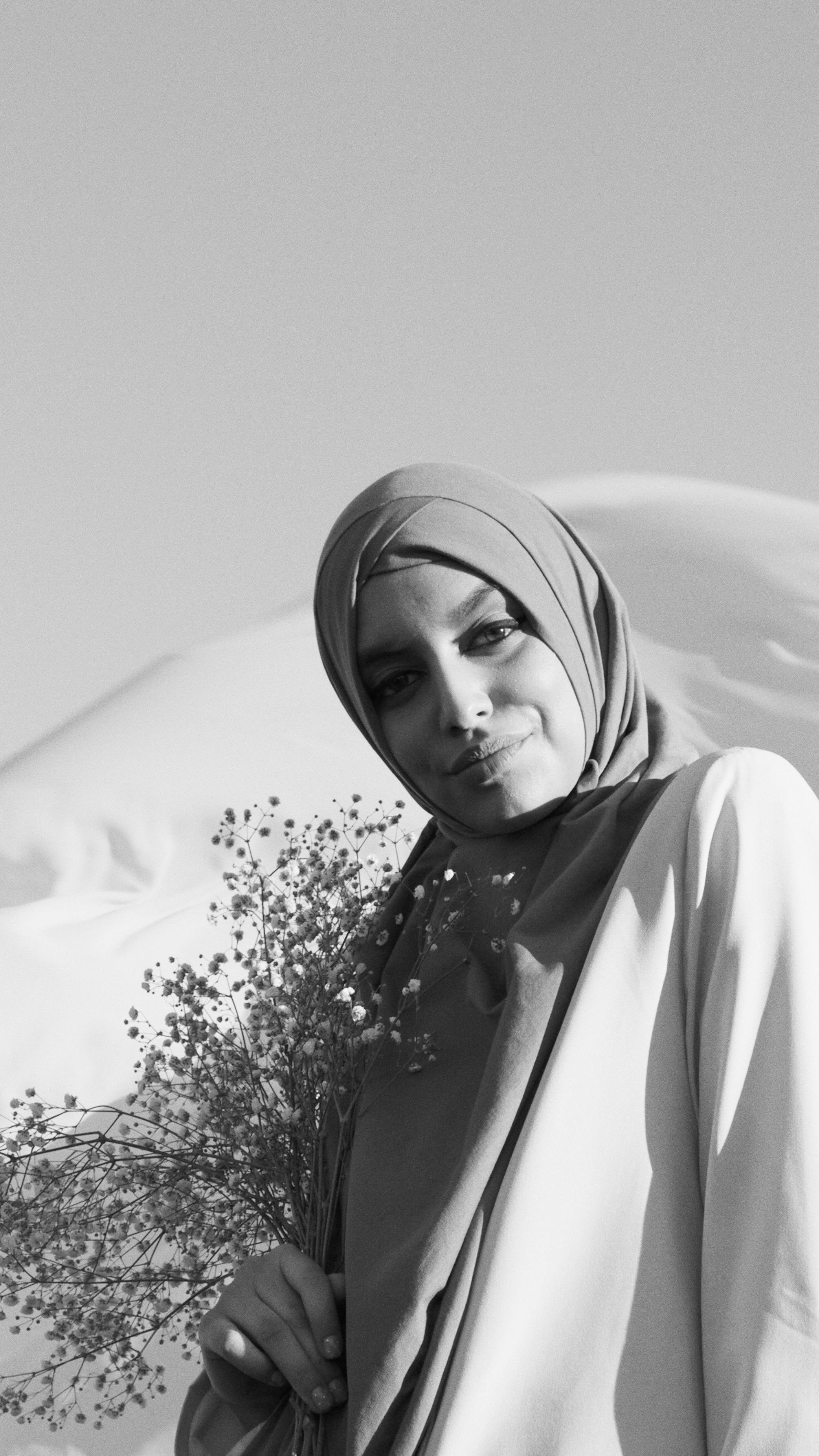 woman in hijab holding flowers