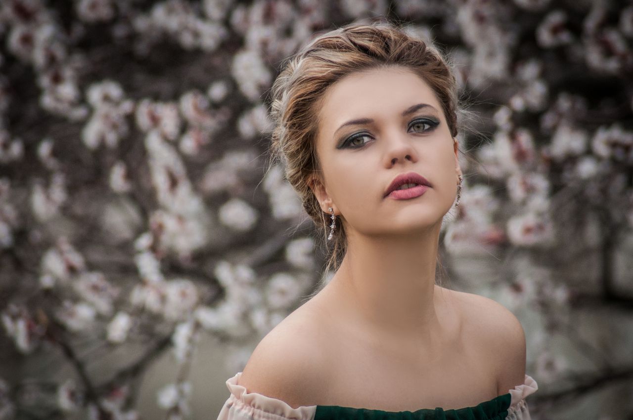 portrait of an elegant woman with charming makeup posing in front of b