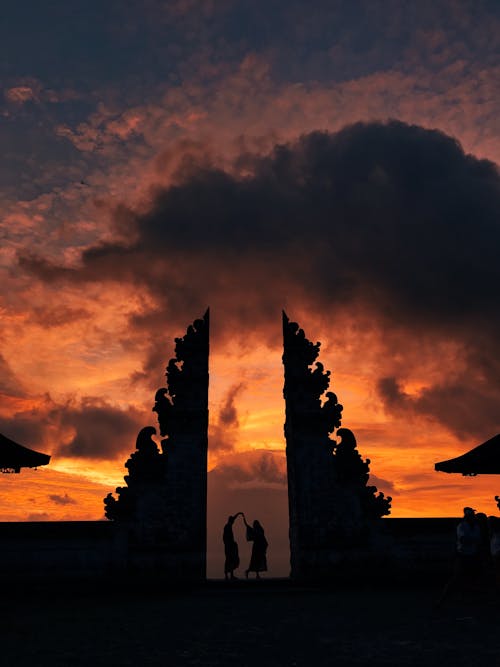 Free People Standing on Pura Lempuyang Luhur Under Orange Sky Stock Photo