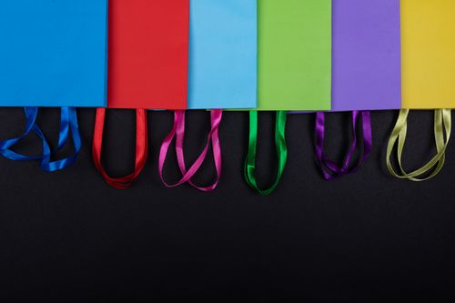 Free Vibrant multicolored paper bags with handles on a black background, viewed from above. Stock Photo
