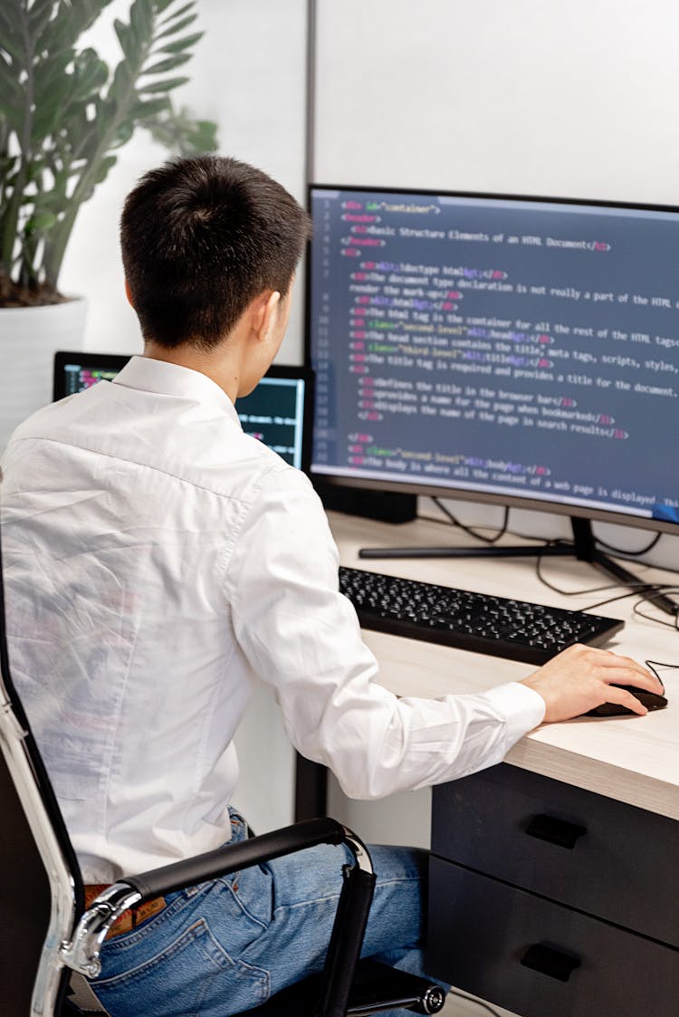 Back View Shot Of A Man Working On His Computer