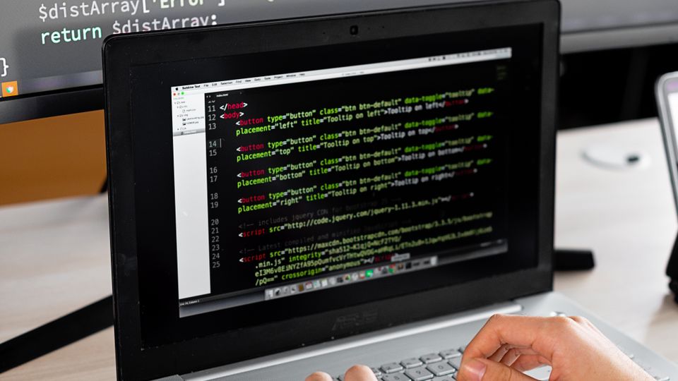 Pessoa desenvolvedora trabalhando com código em um computador, imagem ilustrativa para a atualização do Copilot no Visual Studio.