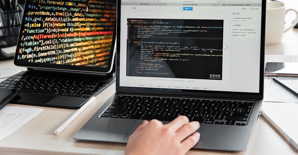 A developer writing code on a laptop, displaying programming scripts in an office environment.