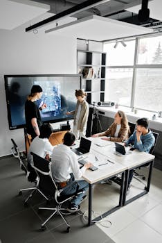 Modern office meeting with diverse team using technology for collaboration.