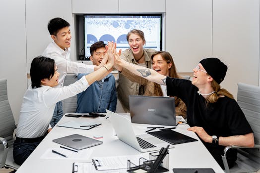 A diverse group of professionals high-fiving in a modern office setting.