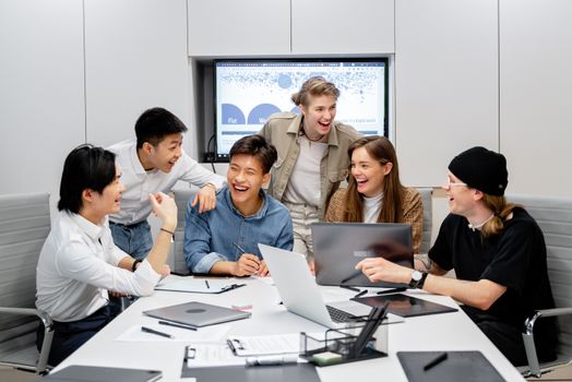 A diverse group of professionals engaging in brainstorming and teamwork in an office environment.