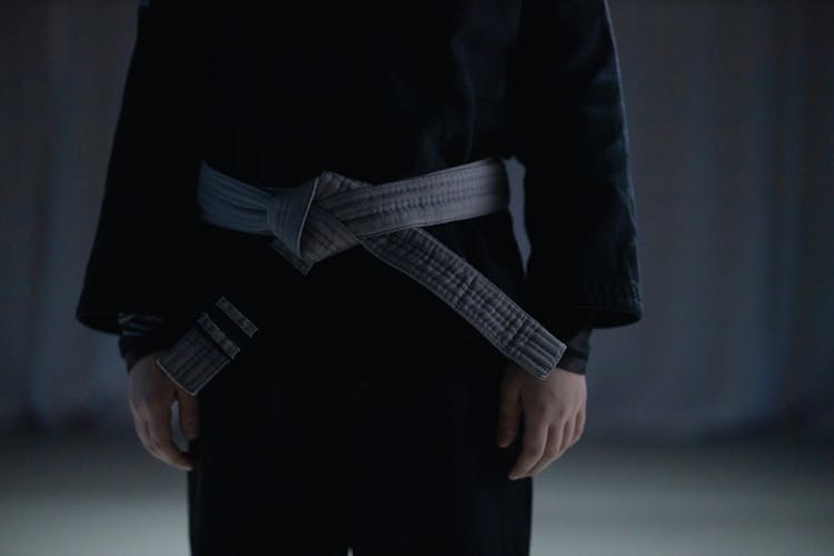 A Person Wearing Black Kimono And Gray Belt