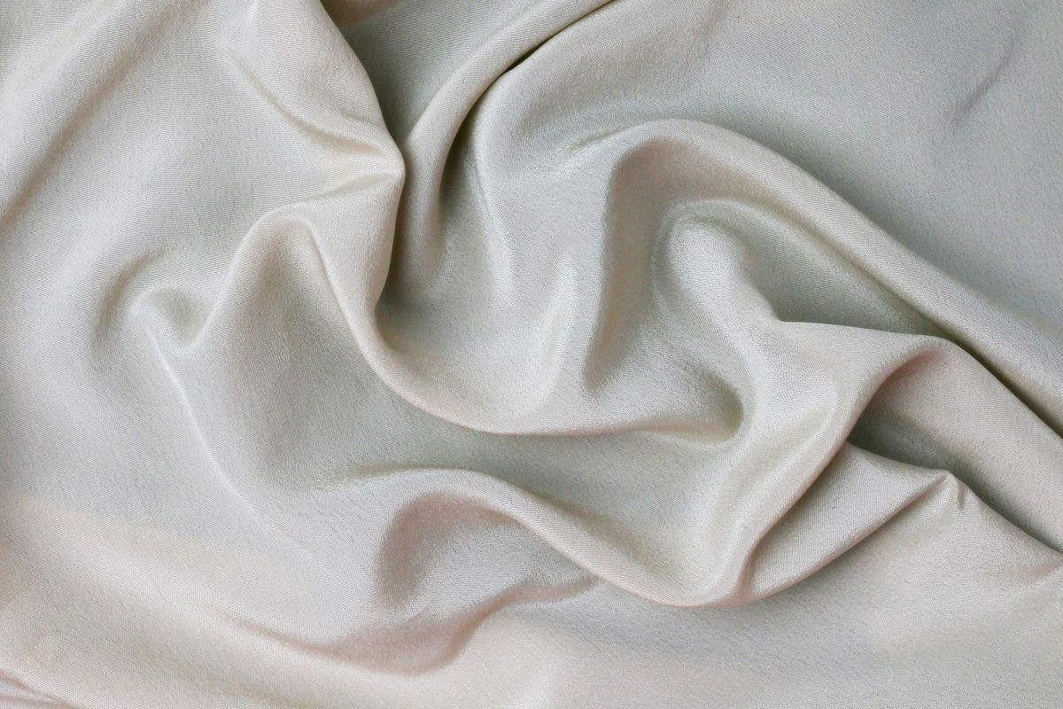 Close detail of cream silk, the weave catching the light