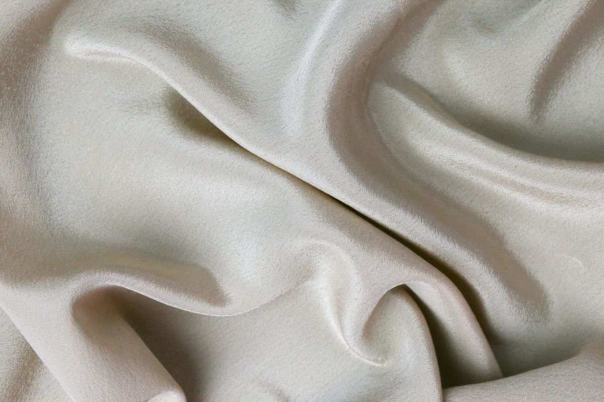 Cream silk falling in soft ripples, shot flat in raking light