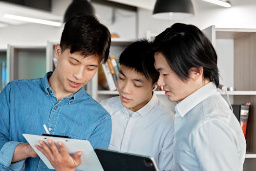 Three colleagues collaborating with digital tablets in a modern office environment, showcasing teamwork and discussion.