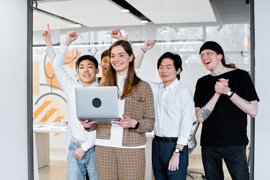 A team celebrating a campaign going live around a laptop