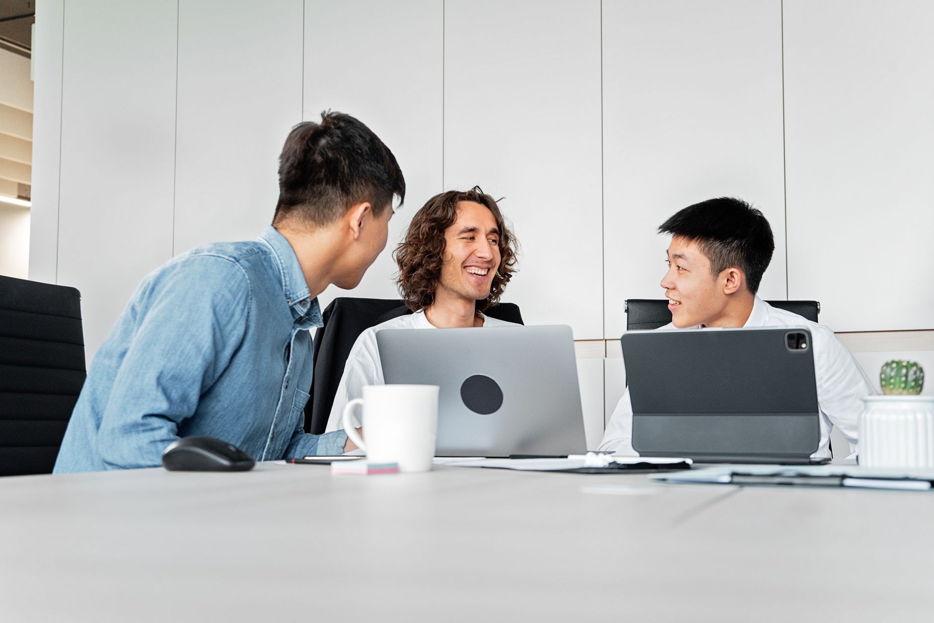 Diverse group of young interns collaborating in a modern Korean government office building, looking at documents and computer screens.