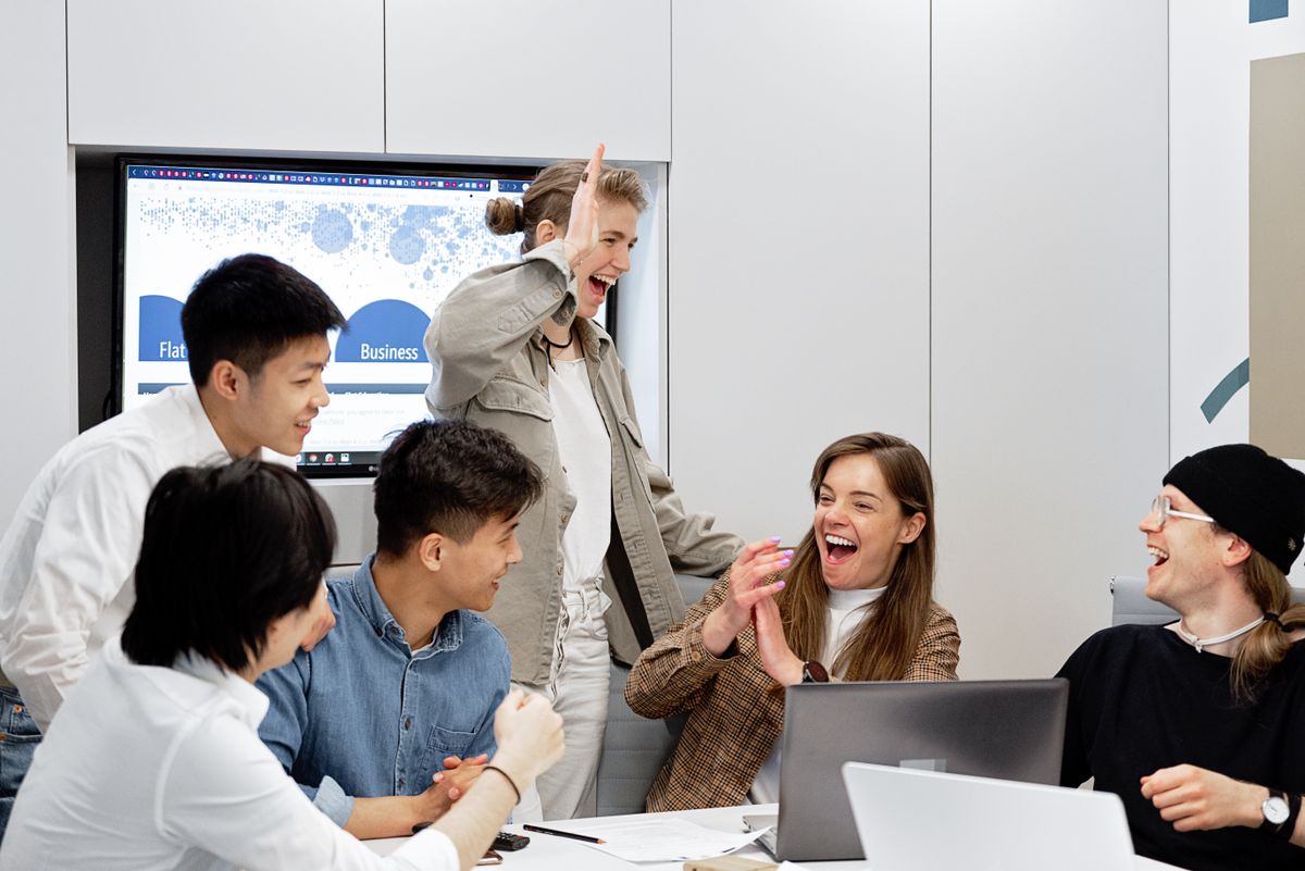 Time de profissionais comemorando resultado em ambiente corporativo moderno