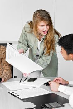 Colleagues in a modern office discussing documents and ideas collaboratively.