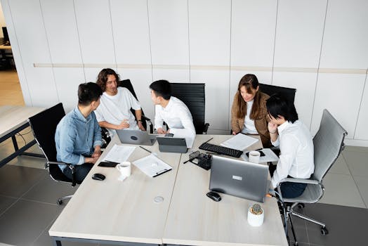 Group of coworkers brainstorming ideas during a collaborative team meeting in a bright office.