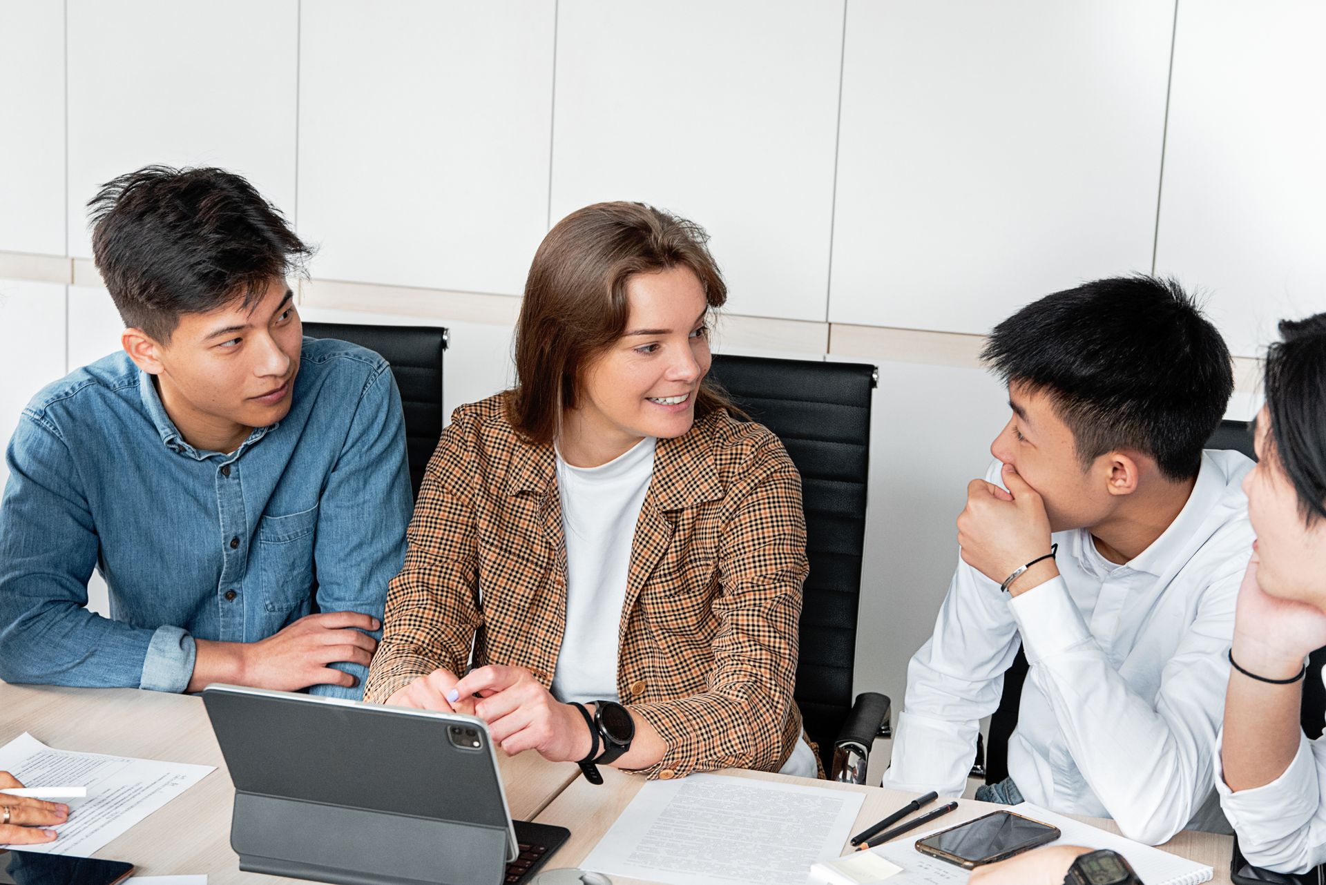A group of young professionals engaged in a collaborative discussion at the office table.