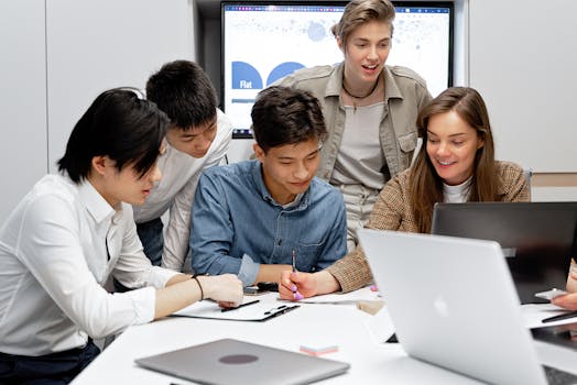 Young professionals brainstorming together with laptops in a bright, modern office.