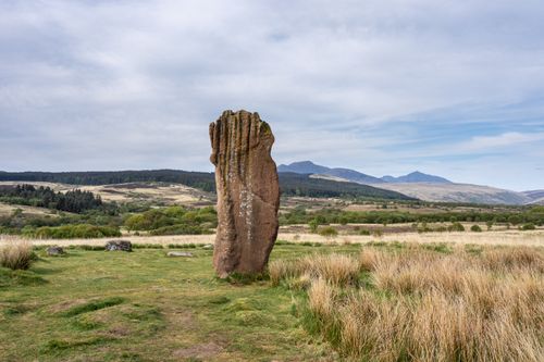 Free Explore a stunning ancient standing stone amidst the scenic Scottish landscape with mountains and grassy fields. Stock Photo