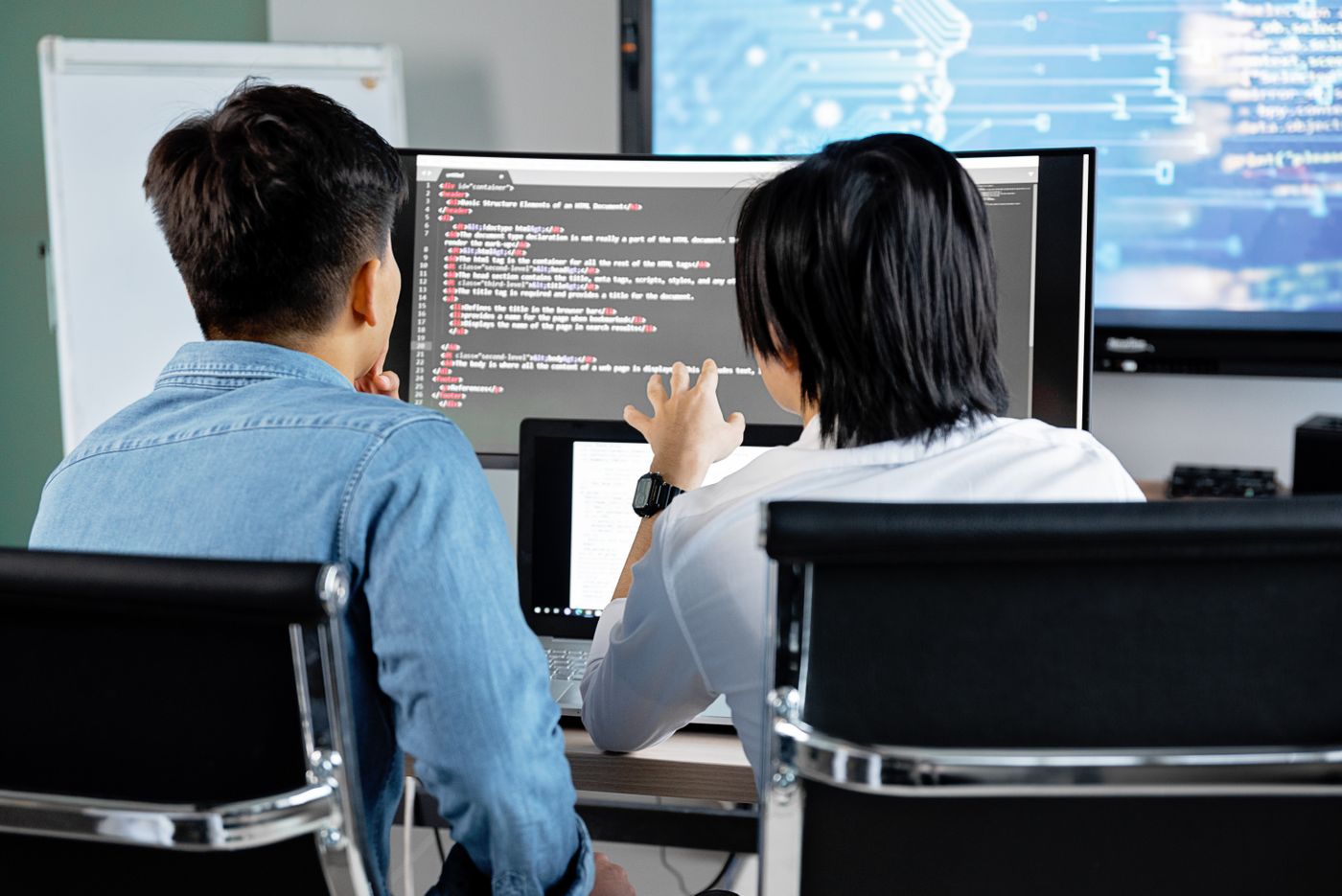 Software developers collaborating on code in a professional office