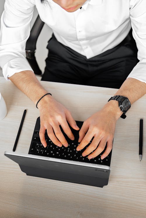 Free Person in White Button Up Shirt Using Black Keyboard Stock Photo