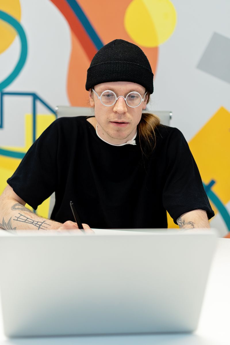 Focused young creative professional working on a laptop in a modern workspace