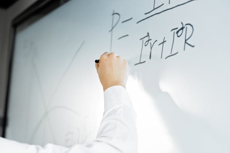 A Person Writing On The Whiteboard