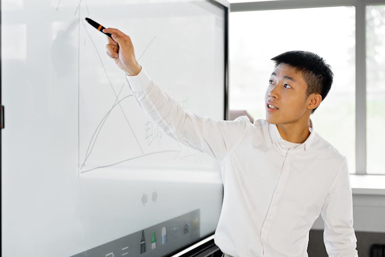 A Man Giving Presentation On The White Screen