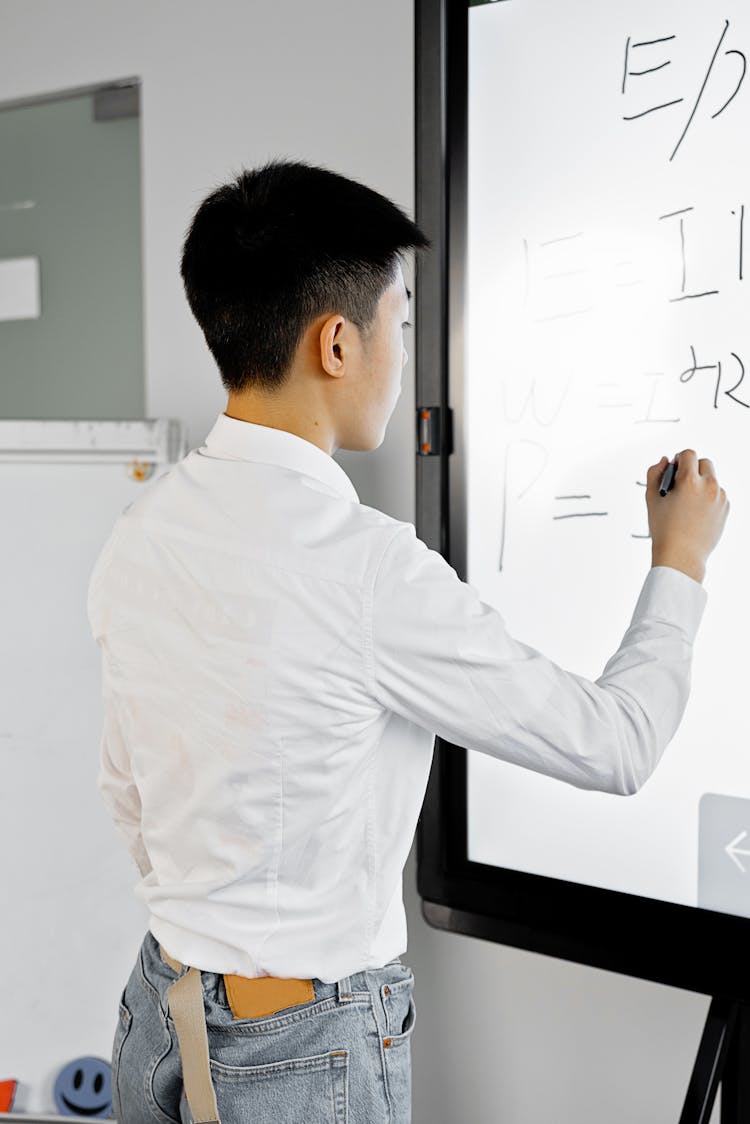 Man In White Long Sleeve Shirt Writing On White Board