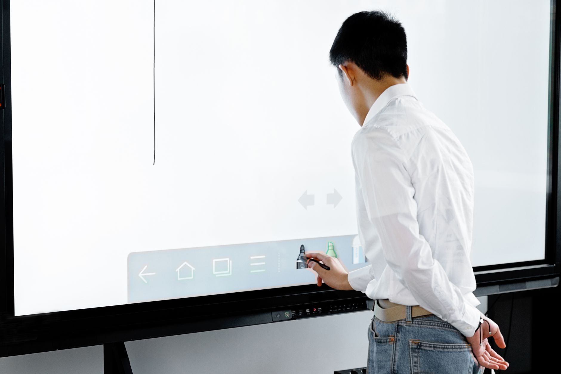 A businessman using a smart board in a modern office setting for interactive presentations.