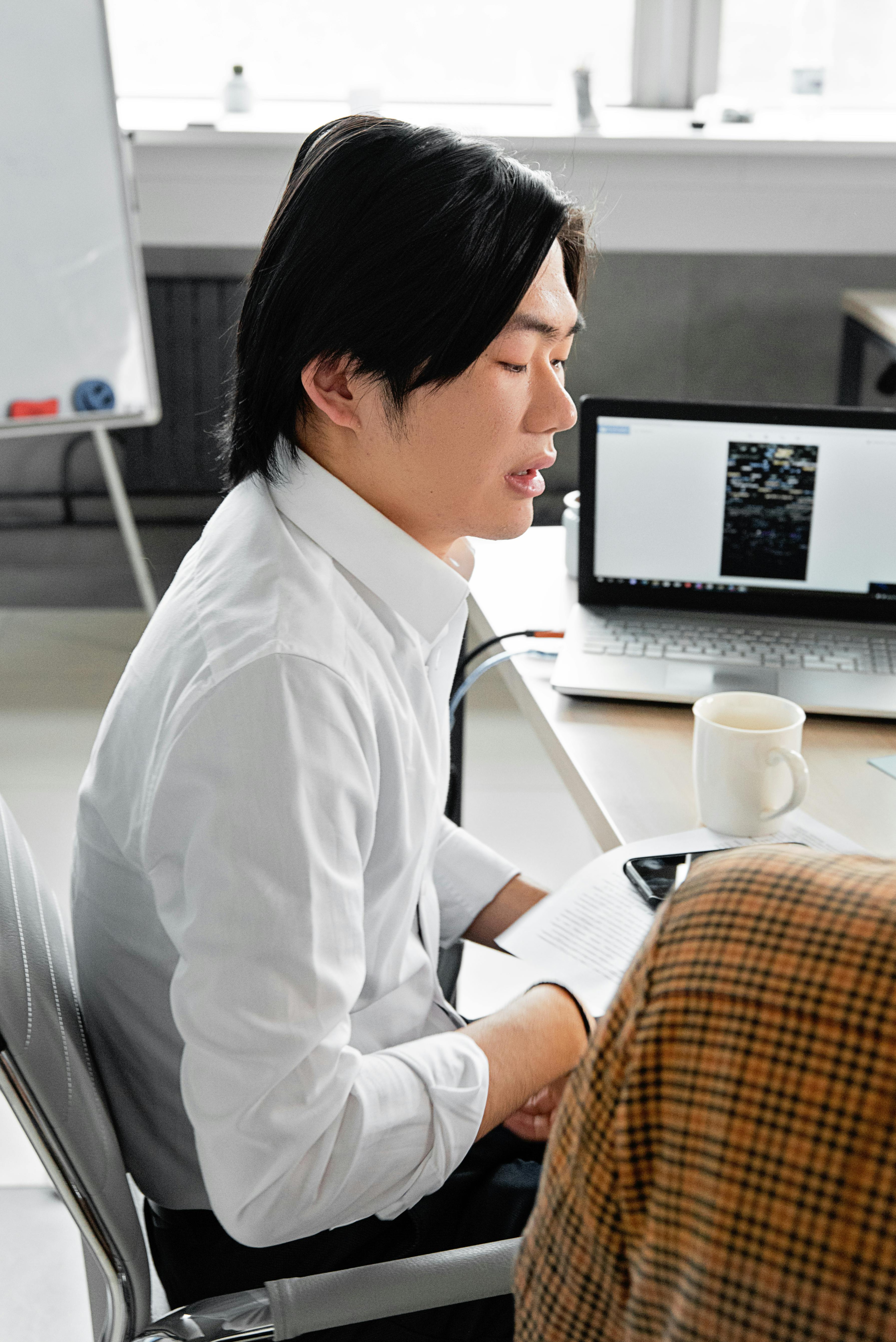 man in white dress shirt sitting on chair