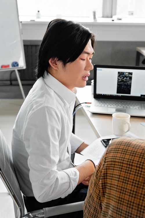 Free Professional Asian man working in office with laptop, notebook, and coffee cup on a table. Stock Photo