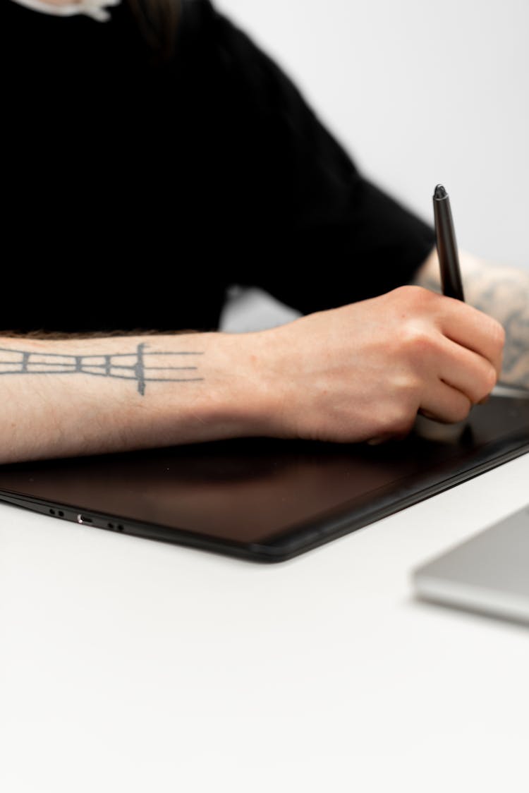 A Person Writing With A Digital Pen