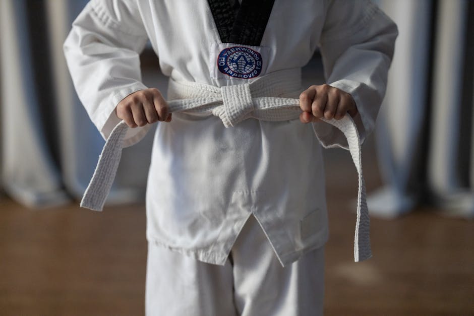 A Person Wearing Dobok Holding the White Belt he is Holding