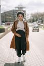 A Pregnant Woman Walking on the Sidewalk