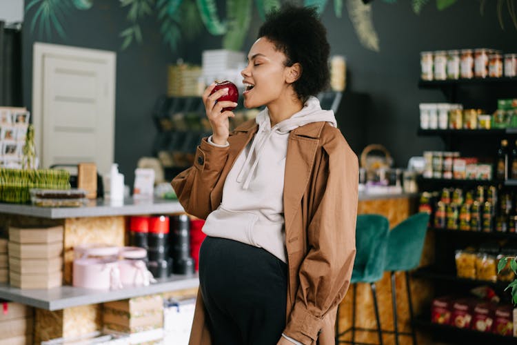 A Pregnant Woman Holding An Apple