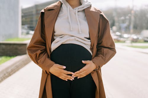 Free A Pregnant Woman Holding Her Baby Bump Stock Photo