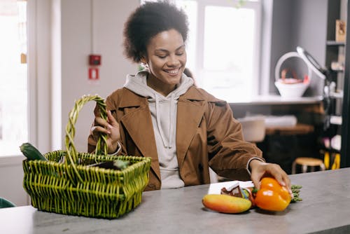 Smiling Woman Holding a Basket and Vegetables