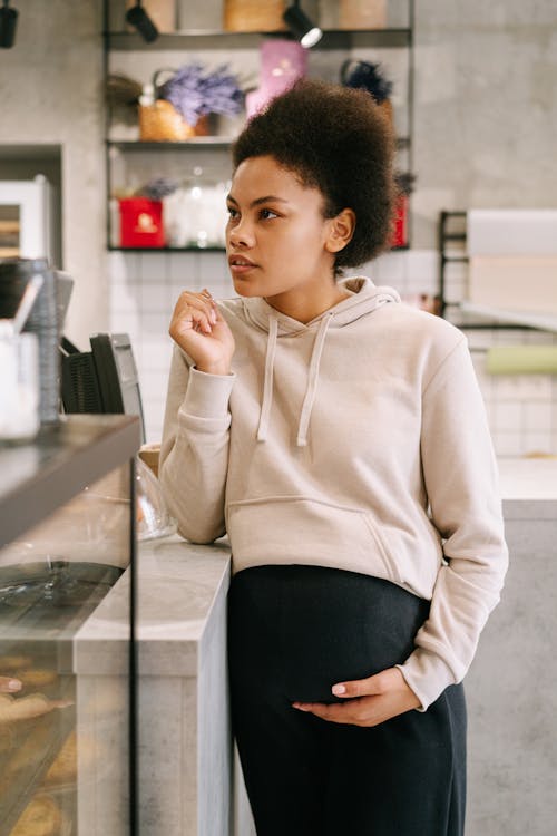 A Pregnant Woman Leaning on a Counter