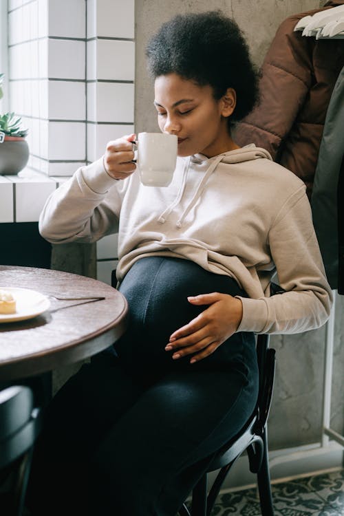 A Pregnant Woman Smelling Her Drink