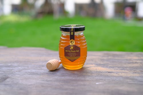 Free Honey Jar with Label on Wooden Surface Stock Photo