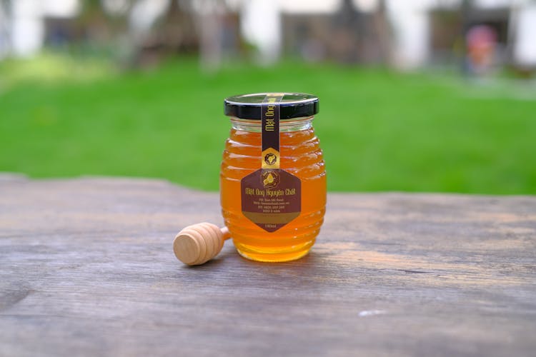 Honey Jar With Label On Wooden Surface